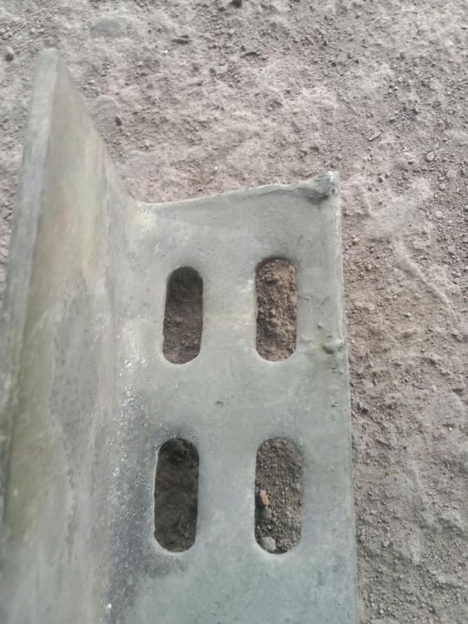 Galvanized slotted angle with lumpy zinc built up along an edge