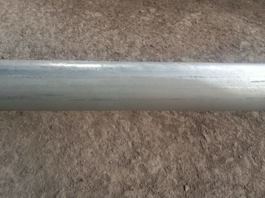Galvanized steel tube with dull grey bands running through the coating