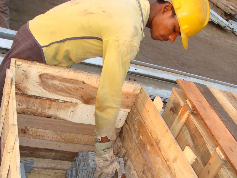 Closing a packing crate. Galvanized cleats being loaded into a wooden crate, in helmet and gloves. Export consignments are packed, marked and documented to the buyer's...