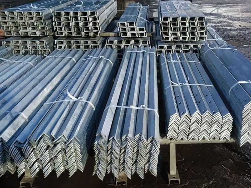 Channels and angles, sorted. Galvanized channels stacked behind the angles. Sections are kept separated by size so a part load can be picked without breaking every bundle.