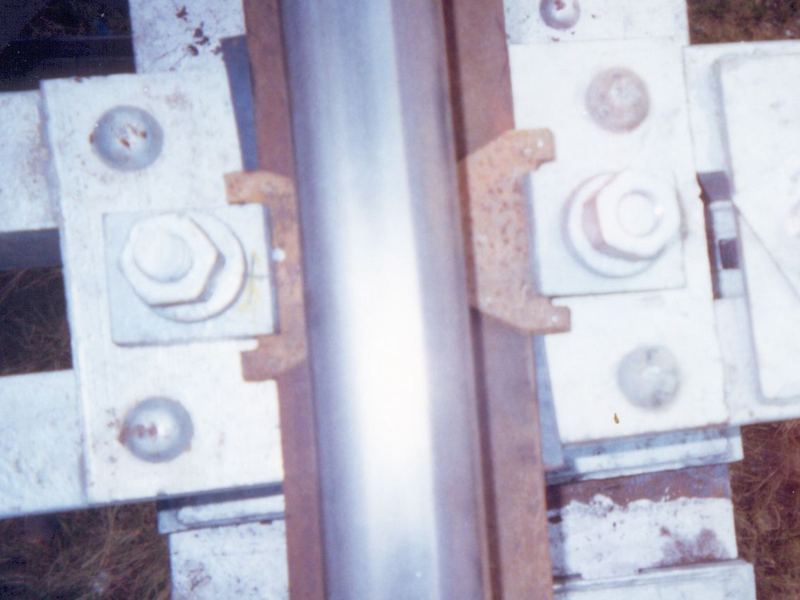 The fastening assembly, close up. The galvanized fastening at a single sleeper seat. On a bridge deck the coating is the whole of the corrosion protection.